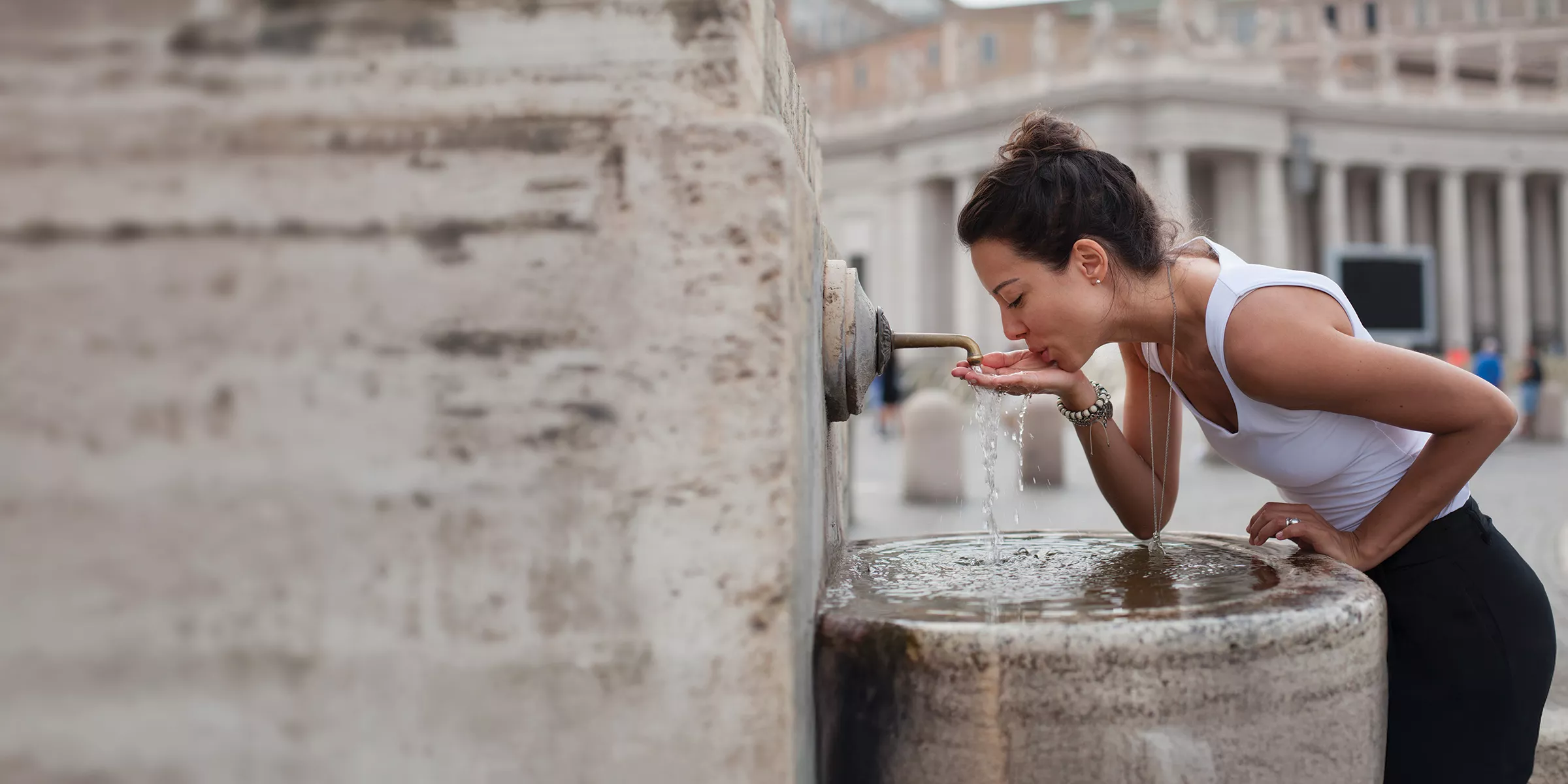 Donna che beve dalla fontana d'acqua