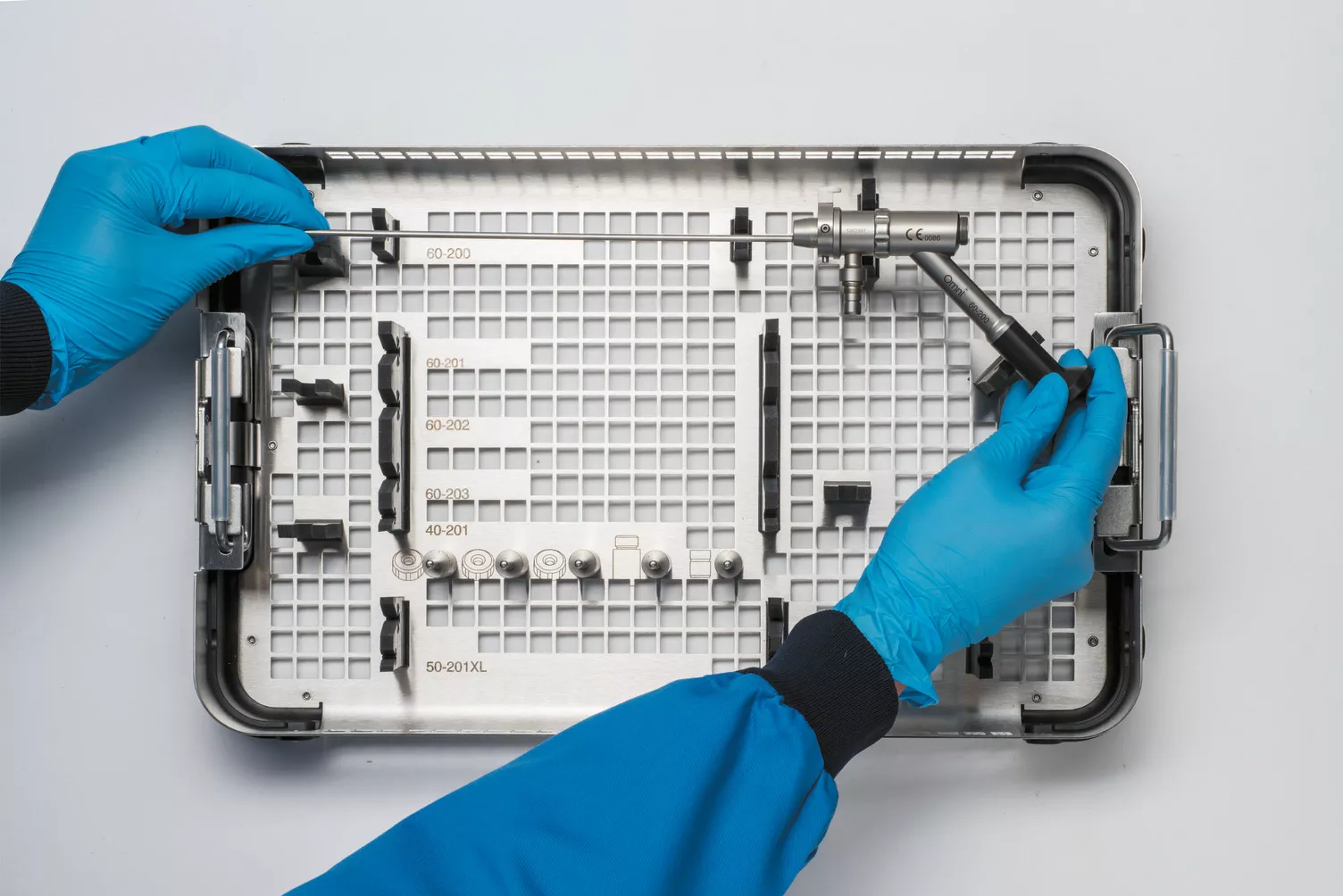 Mani con guanti che lavorano su un cestello appoggiato a un ripiano.