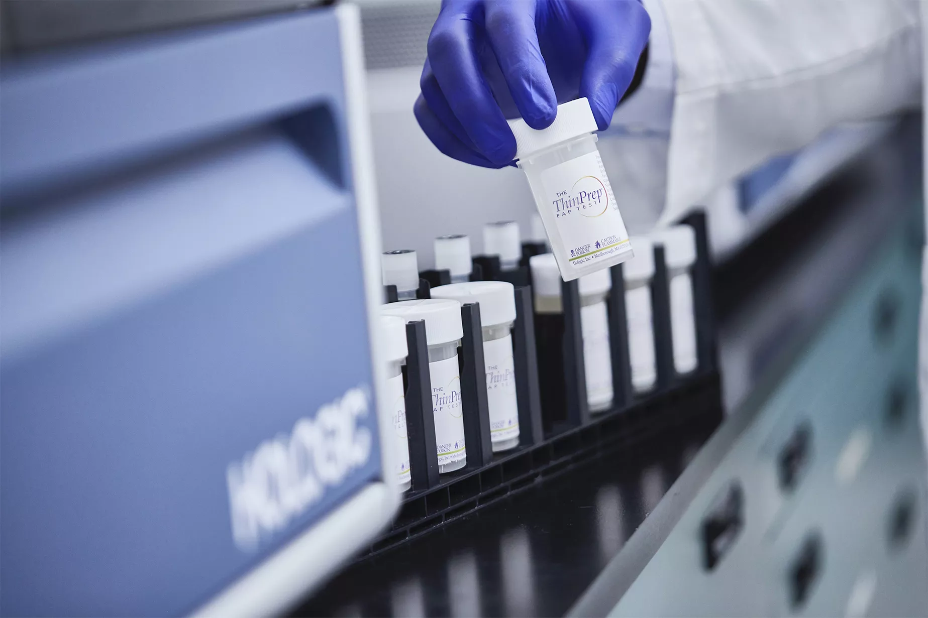 Mano con guanto che tiene una fiala