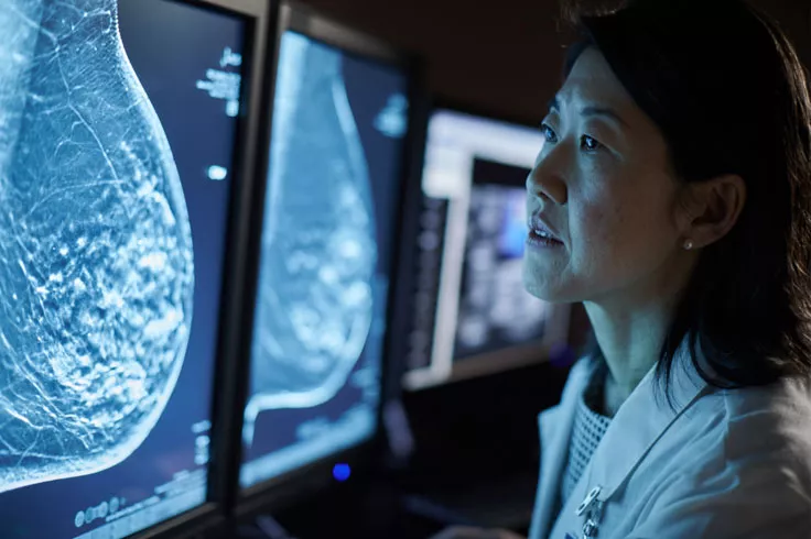 Operatore sanitario che osserva radiografie su monitor